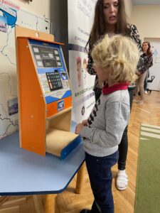 dziecko wypłaca pieniadze z zabawkowego bankomatu