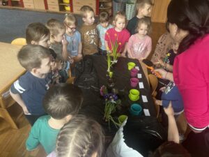 Nauczyciel pokazuje dzieciom ziemię (oglądają, dotykają, wąchają)